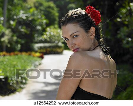 Stock Image - Young Woman with Flower in Hair. Fotosearch