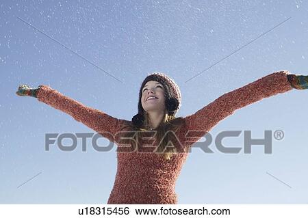 Stock Photograph - 14 year old girl in winter clothing with arms outstretched. Fotosearch