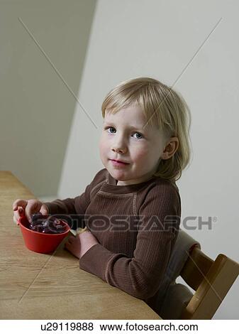 4-5 year old girl sits eating abowl of fruit View Large Photo Image Stock Photo - 4-5 year old girl sits eating abowl of fruit. Fotosearch