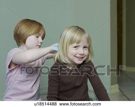 7-8 year old girl combs 4-5 year old girls hair View Large Photo Image Stock Photo - 7-8 year old girl combs 4-5 year old girls hair. Fotosearch