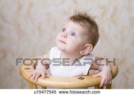 Baby boy sitting on high chair looking up View Large Photo Image Stock Photography - Baby boy sitting on high chair looking up. Fotosearch