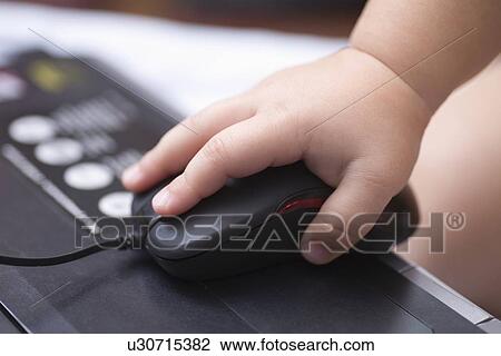 Baby's hand holds computer mouse View Large Photo Image Stock Image - Baby's hand holds computer mouse. Fotosearch