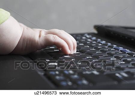 Stock Image - Baby's hand on computer keyboard. Fotosearch