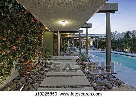 Back yard with swimming pool alongside modern house View Large Photo Image Stock Image - Back yard with swimming pool alongside modern house. Fotosearch