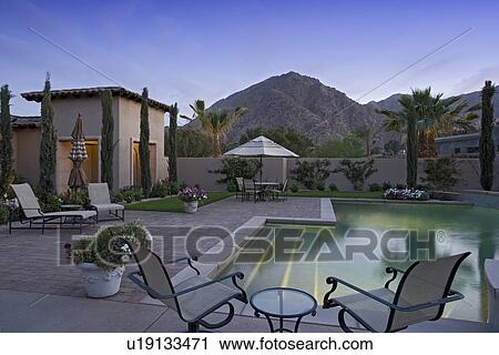 Stock Image - Back yard with swimming pool alongside modern home. Fotosearch