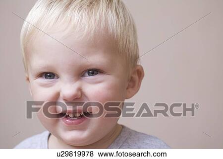 Stock Photo - Blonde toddler scrunches his face in laughter. Fotosearch