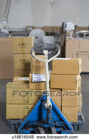 Boxes stacked on trolley in distribution warehouse View Large Photo Image Stock Photo - Boxes stacked on trolley in distribution warehouse. Fotosearch