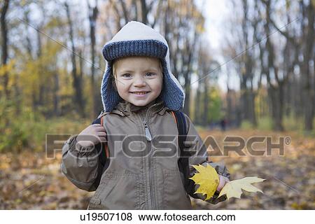 Stock Photo - Boy holding leaves in park portrait. Fotosearch