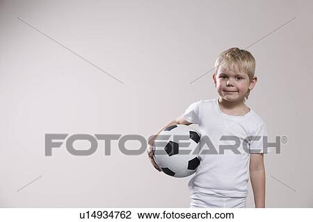 Stock Image - Boy holding soccer ball portrait. Fotosearch