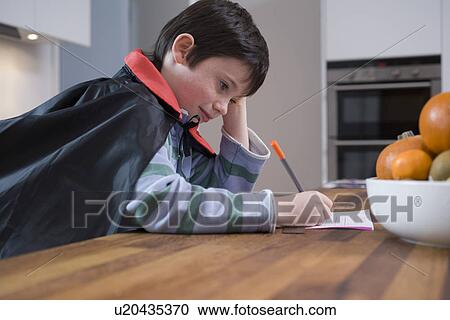 Stock Image - Boy in costume drawing at table. Fotosearch