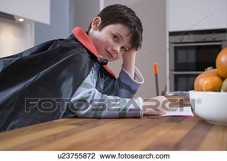 Boy in costume drawing at table View Large Photo Image Stock Image - Boy in costume drawing at table. Fotosearch