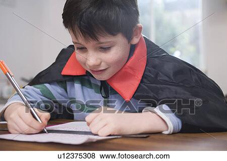 Boy in costume drawing at table View Large Photo Image Stock Photo - Boy in costume drawing at table. Fotosearch
