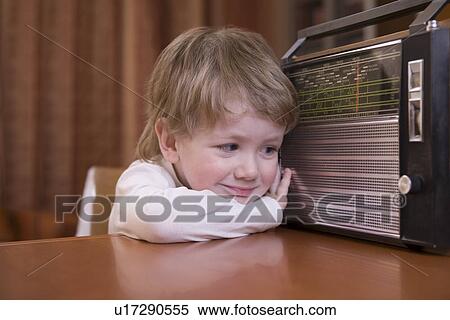Stock Photography - Boy listening to retro radio. Fotosearch