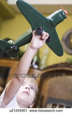 Boy playing with model airplane in home View Large Photo Image Stock Image - Boy playing with model airplane in home. Fotosearch