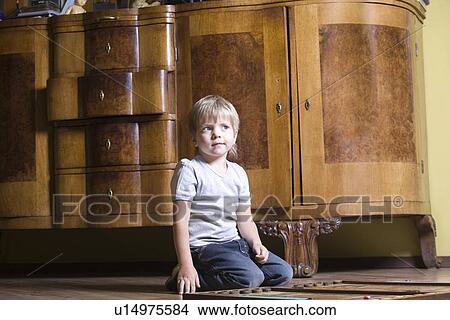 Picture - Boy playing wooden game on floor. Fotosearch
