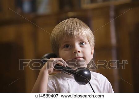 Stock Photo - Boy using telephone at home. Fotosearch