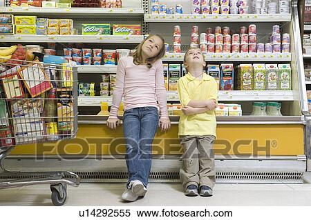 Brother and sister sit side by side on fridge counter in supermarket View Large Photo Image Stock Photography - Brother and sister sit side by side on fridge counter in supermarket. Fotosearch