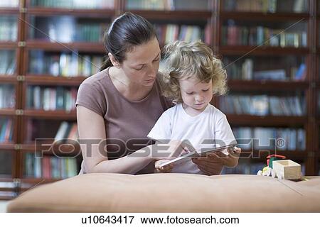 Brunette woman teaches blonde toddler how to read View Large Photo Image Stock Photo - Brunette woman teaches blonde toddler how to read. Fotosearch