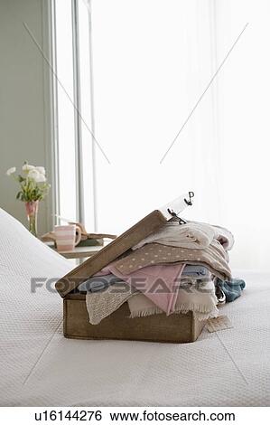 Bulging suitcase on a bed View Large Photo Image Stock Photograph - Bulging suitcase on a bed. Fotosearch