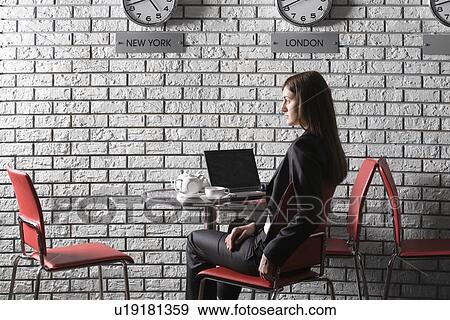 Stock Photo - Business woman using laptop in cafe. Fotosearch