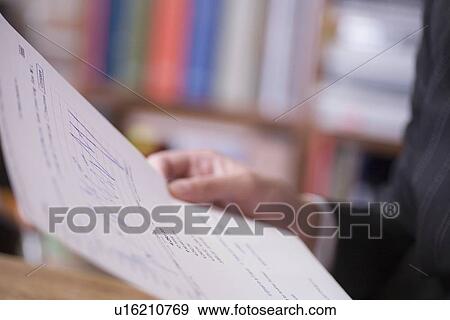 Stock Photo - Businessman holds report. Fotosearch