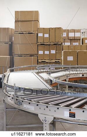 Cardboard boxes and conveyor belt in distribution warehouse View Large Photo Image Stock Image - Cardboard boxes and conveyor belt in distribution warehouse. Fotosearch