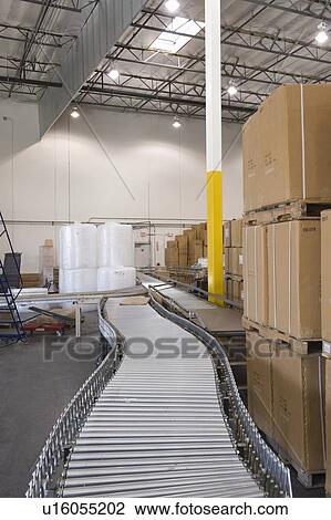 Cardboard boxes and conveyor belt in distribution warehouse View Large Photo Image Stock Image - Cardboard boxes and conveyor belt in distribution warehouse. Fotosearch
