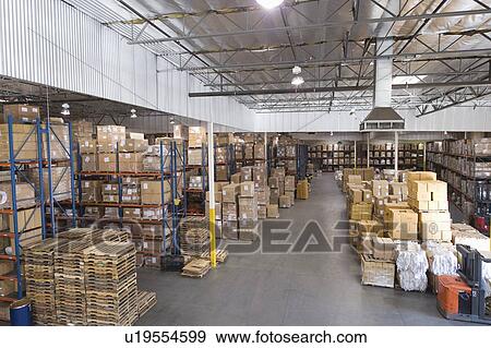 Stock Photo - Cardboard boxes stacked in distribution warehouse. Fotosearch