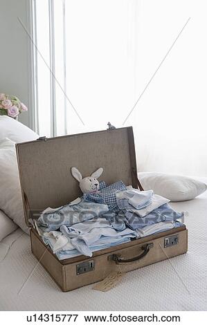 Stock Photo - Childrens clothing in a suitcase. Fotosearch