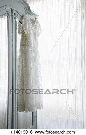 Christening gown on wardrobe at window with net curtains View Large Photo Image Stock Photograph - Christening gown on wardrobe at window with net curtains. Fotosearch