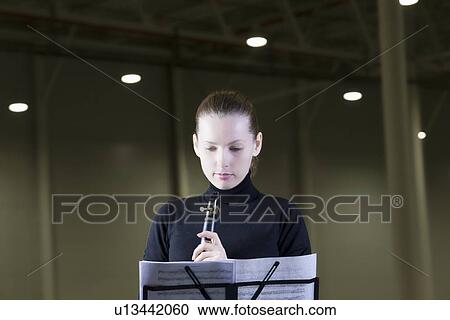 Clarinet player stands with sheet music under spotlights View Large Photo Image Stock Image - Clarinet player stands with sheet music under spotlights. Fotosearch