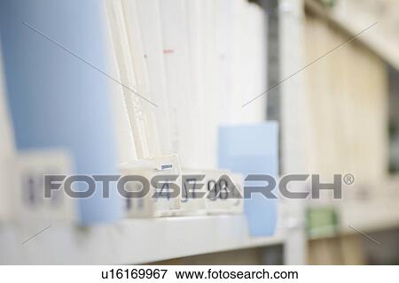 Stock Photo - Colour coded filing system on library shelves. Fotosearch