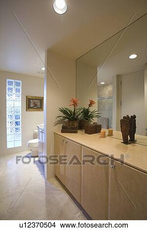 Cupboard storage and large mirror with glass bricks in palm Springs bathroom View Large Photo Image Picture - Cupboard storage and large mirror with glass bricks in palm Springs bathroom. Fotosearch