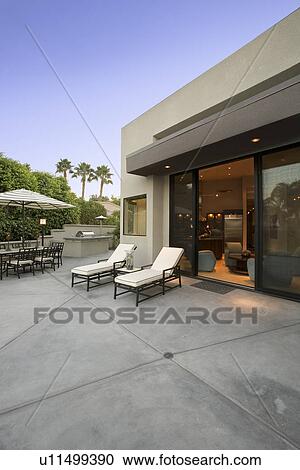 Stock Image - Deckchairs outside modern residence. Fotosearch