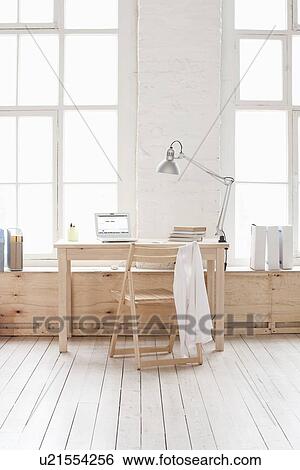 Stock Photograph - Desk in window area of loft apartment. Fotosearch