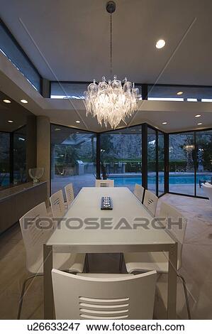 Dining table of Palm Springs home lit with glass chandelier View Large Photo Image Stock Photo - Dining table of Palm Springs home lit with glass chandelier. Fotosearch