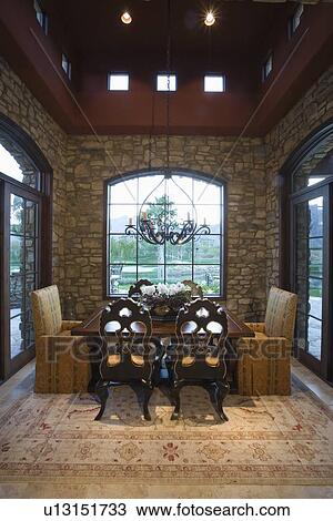 Stock Image - Dining table with sofas at window in Palm Springs home. Fotosearch