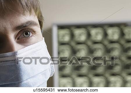 Stock Image - Doctor wearing surgical mask close-up. Fotosearch