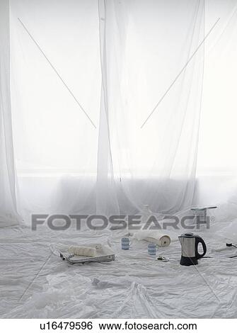 Stock Photograph - Empty room covered in dust sheets with kettle and painting supplies. Fotosearch