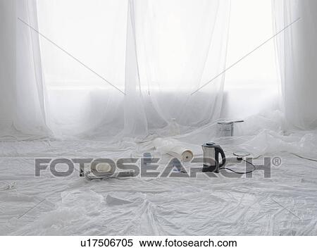 Stock Photography - Empty room covered in dust sheets with kettle and painting supplies. Fotosearch