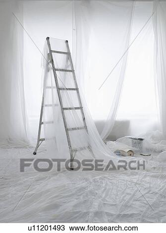 Stock Image - Empty room covered in transparent dust sheets prepared for painting and decorating. Fotosearch