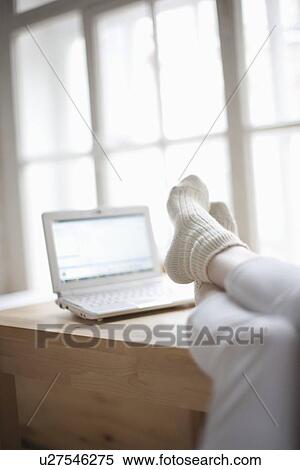 Stock Photography - Feet up in loft apartment with laptop. Fotosearch