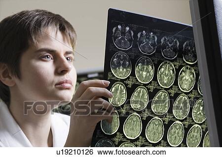 Female doctor analyzing CAT scan View Large Photo Image Stock Photograph - Female doctor analyzing CAT scan. Fotosearch