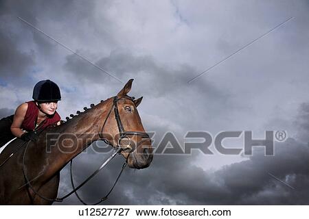Female jockey riding horse View Large Photo Image Stock Photo - Female jockey riding horse. Fotosearch