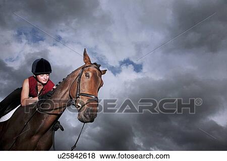 Female jockey riding horse View Large Photo Image Stock Photo - Female jockey riding horse. Fotosearch