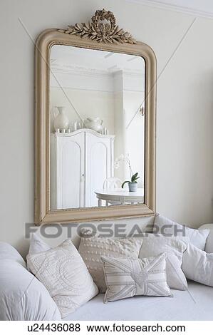 Framed mirror above daybed with cushions View Large Photo Image Stock Photo - Framed mirror above daybed with cushions. Fotosearch