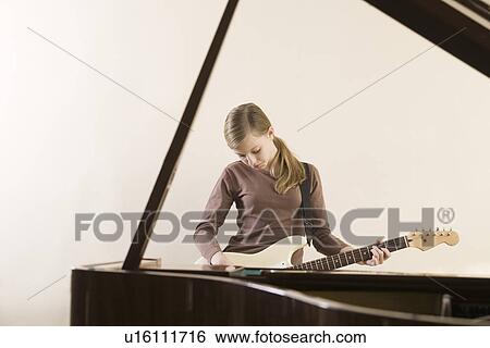 Girl (13-15) playing guitar View Large Photo Image Stock Photograph - Girl (13-15) playing guitar. Fotosearch