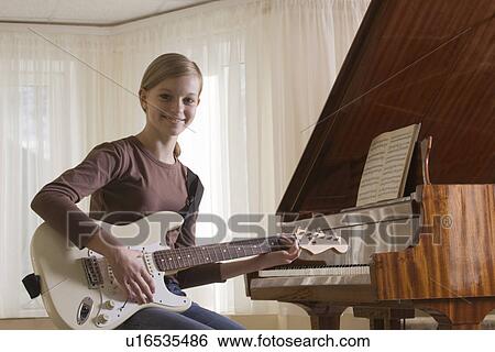 Girl (13-15) playing guitar View Large Photo Image Stock Photograph - Girl (13-15) playing guitar. Fotosearch