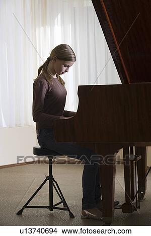 Picture - Girl (13-15) playing piano. Fotosearch