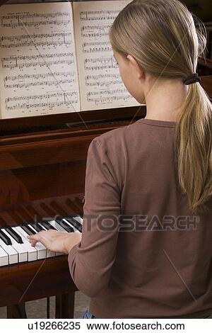 Stock Photography - Girl (13-15) playing piano. Fotosearch